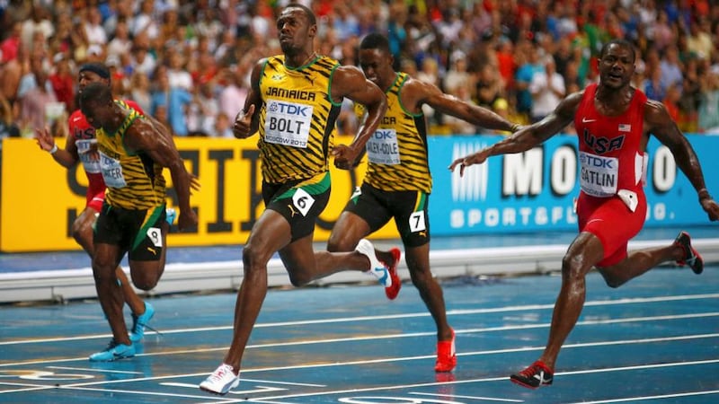Usain Bolt of Jamaica (centre) crosses the finish line ahead of Justin Gatlin (right). Photograph: Kai Pfaffenbach/Reuters