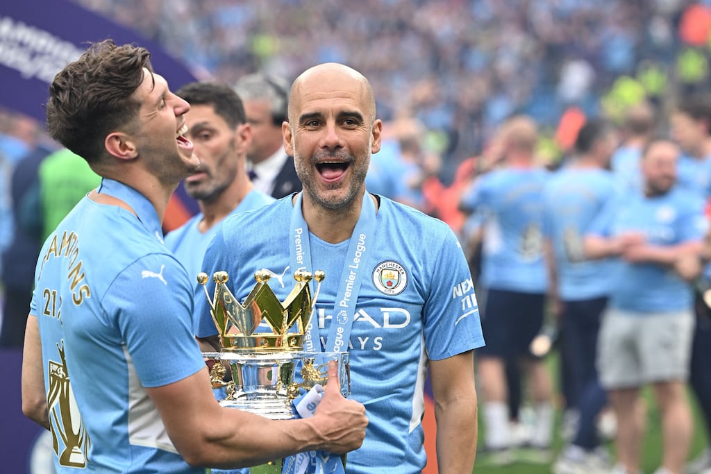 Manchester City manager Pep Guardiola (right) and defender John Stones celebrate with the Premier League trophy after claiming the title in Manchester on May 22nd, 2022. Photograph: Oli Scarff/AFP via Getty
