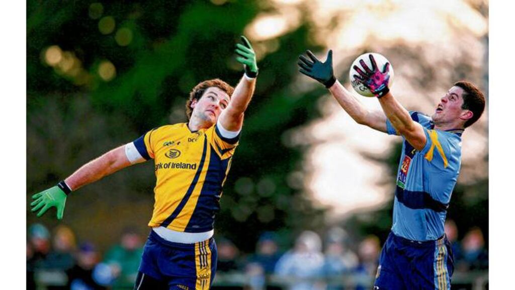 DCU's Michael Murphy is beaten to the ball by UCD's Rory O'Carroll in yesterday's Sigerson game . Photograph: Lorraine O'Sullivan/Inpho