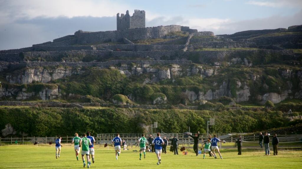 Oileáin Árainn in green, playing against Micheál Breathnach’s from Indreabhán, Connemara at Inis Oírr Park with the 14th century O’Brien castle in the background. PIc: Seán Ó Mainnín
