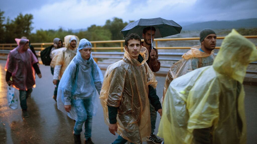 Migrants and refugees walk to board a bus after crossing the Greek-Macedonian border, near Gevgelija on Thursday. Photograph: Robert Atanasovski/AFP/Getty
