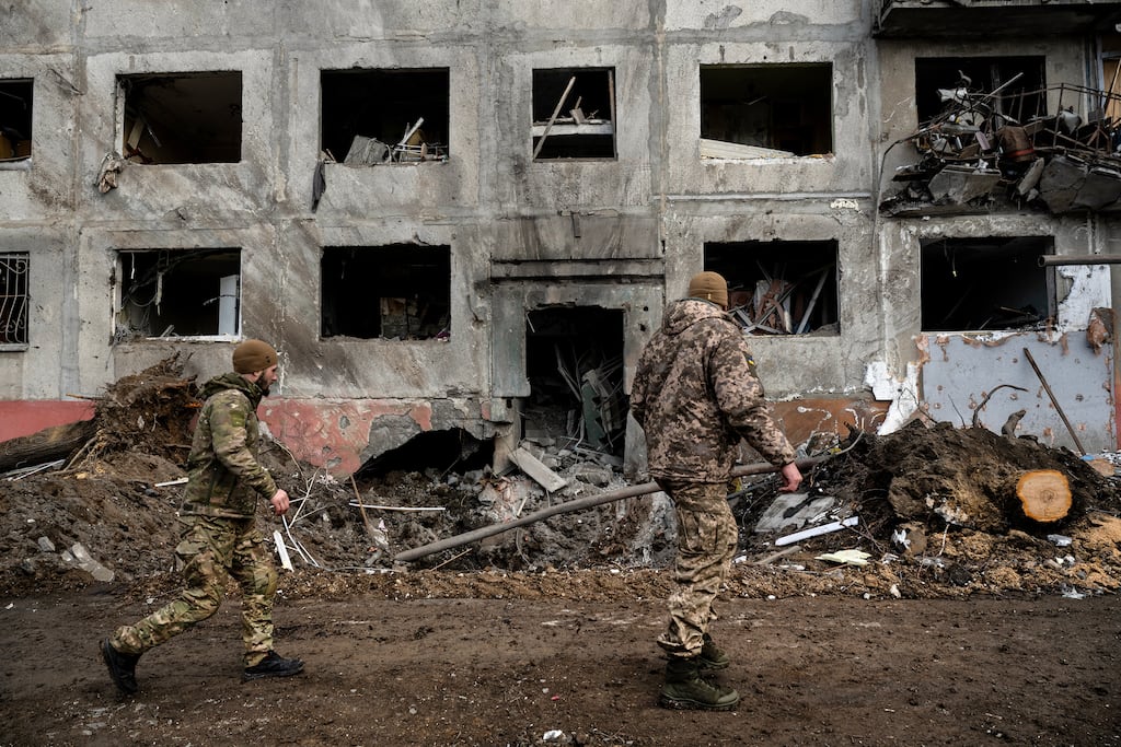 Ukrainian soldiers walk past a crater in front of a high-rise building last month a day after a missile attack in Druzhkivka, in eastern Ukraine. Photograph: Lynsey Addario/The New York Times