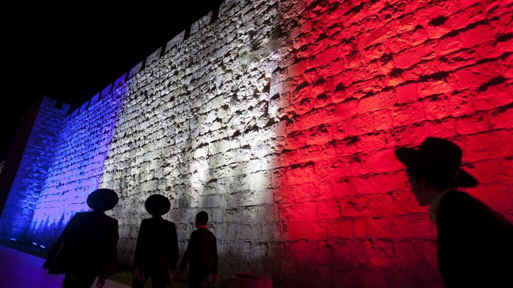Ultra-orthodox Jewish men pass Jerusalem’s Old City wall as it is illuminated yesterday with the colours of the French national flag in a gesture to show solidarity with the victims of the Paris attacks. Photograph: Lior Mizrahi/Getty Images