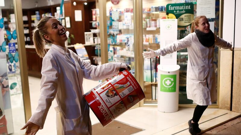 Pharmacy employees in Ronda,, Spain sing as people applaud them from their windows and balconies as part of an event organized through social media to show gratitude to healthcare workers. Photograph: Jon Nazca/Reuters