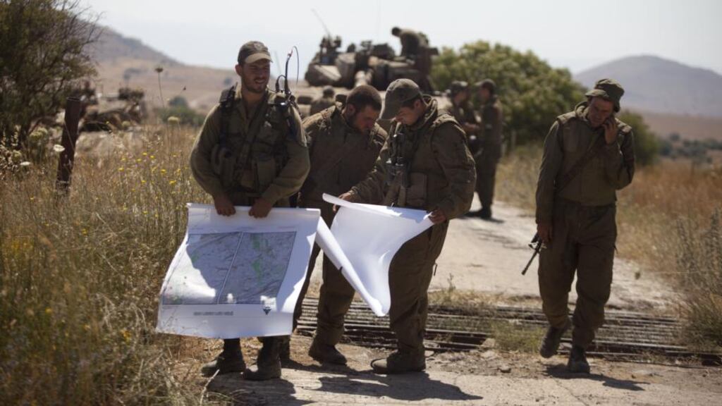 Israeli soldiers look at maps on the Israeli-Syrian border near Quneitra today following the killing of an Israeli teenager and the wounding of three men, one seriously, in an attack near the border fence with Syria in the Golan Heights. Photograph: Lior Mizrahi/Getty Images