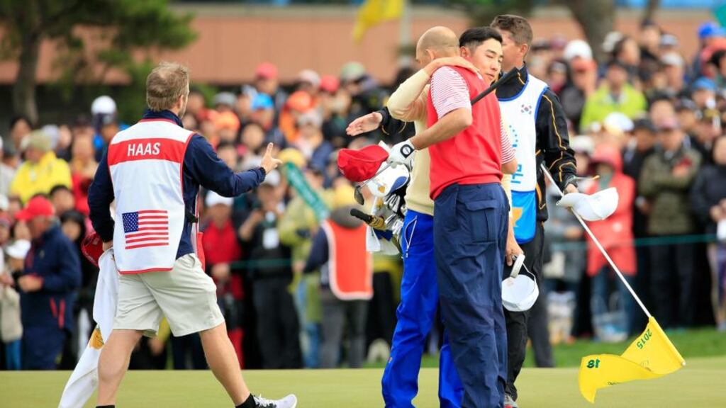 Bill Haas of the United States shakes hands with Sang-moon Bae of South Korea and the International team after Haas won the final match on the 18th green to help his side retain the title. Photograph:  David Cannon/Getty Images