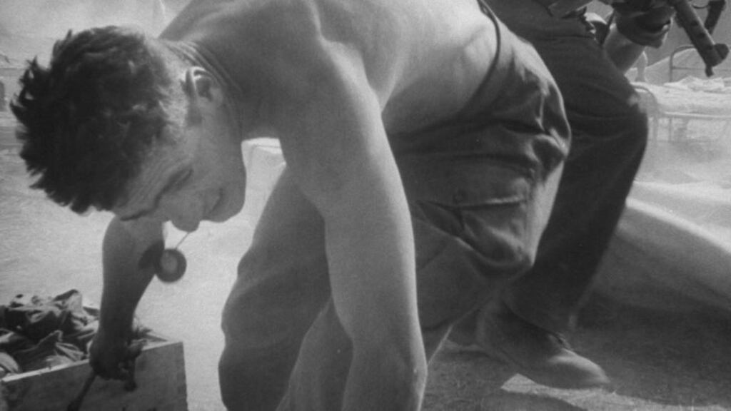 Irish troops taking cover as an ammunition tent catches fire. Photograph: Terrence Spencer / The LIFE Images Collection / Getty Images