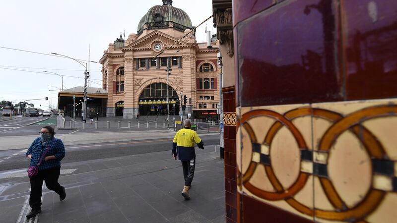 A person wearing a face mask walks outside of Flinders Street Station in Melbourne, Australia, August 6th 2020. Photograph: James Ross/EPA