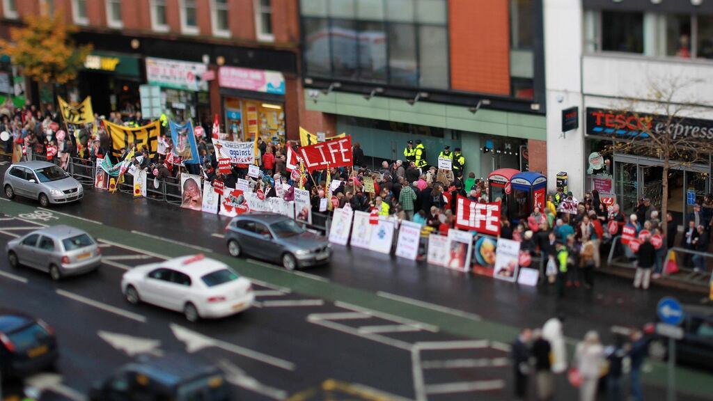 Police stand at the entrance of the Marie Stopes clinic as anti-abortion protestors hold up placards outside the Belfast clinic in October 2012. Photograph: Peter Muhly/AFP/Getty Images