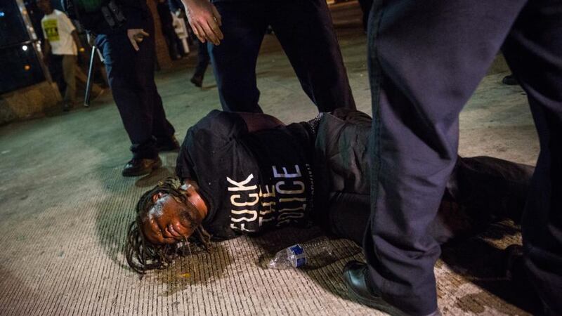A man is detained after being pepper sprayed in the face by police at the end of a day of protests in the Sandtown neighborhood where Freddie Gray was arrested on Saturday  in Baltimore, Maryland. Photograph: Getty
