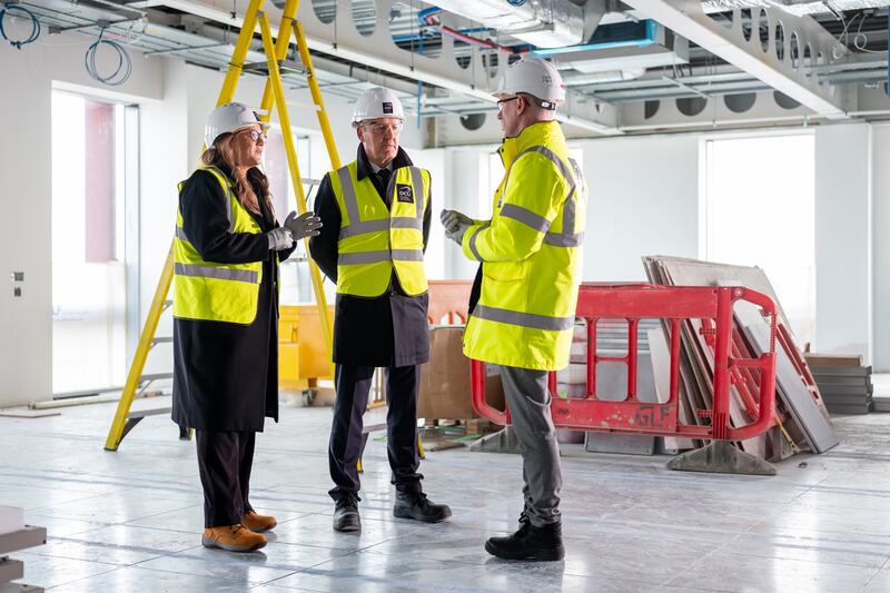 Rafter and Moody of Mitsubishi Electric chat with Alan Managan, estate manager at DCU, inside the new Polaris building at DCU where Mitsubishi Electric HVRF systems can be seen in the ceiling above