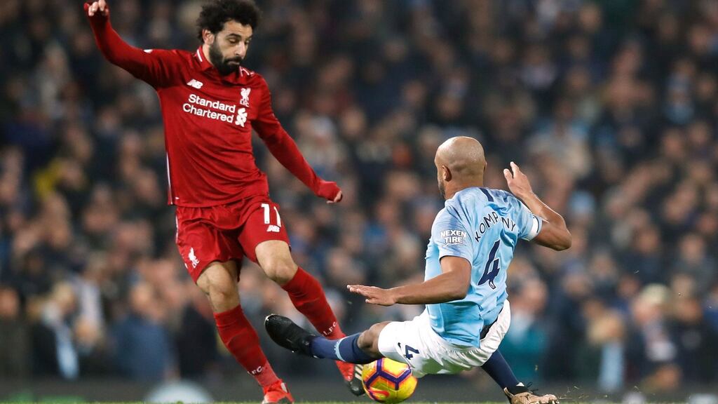 Manchester City’s Vincent Kompany tackles Liverpool’s Mohamed Salah during the Premier League game at the Etihad stadium. Kompany received a yellow card for the challenge. Photograph: Martin Rickett/PA Wire