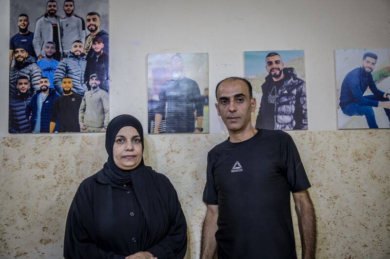 Falasteen Salameh and her husband Ahmed at their home in Jenin refugee camp in front of photos of their sons, who have been imprisoned since last November. Photograph: Sally Hayden