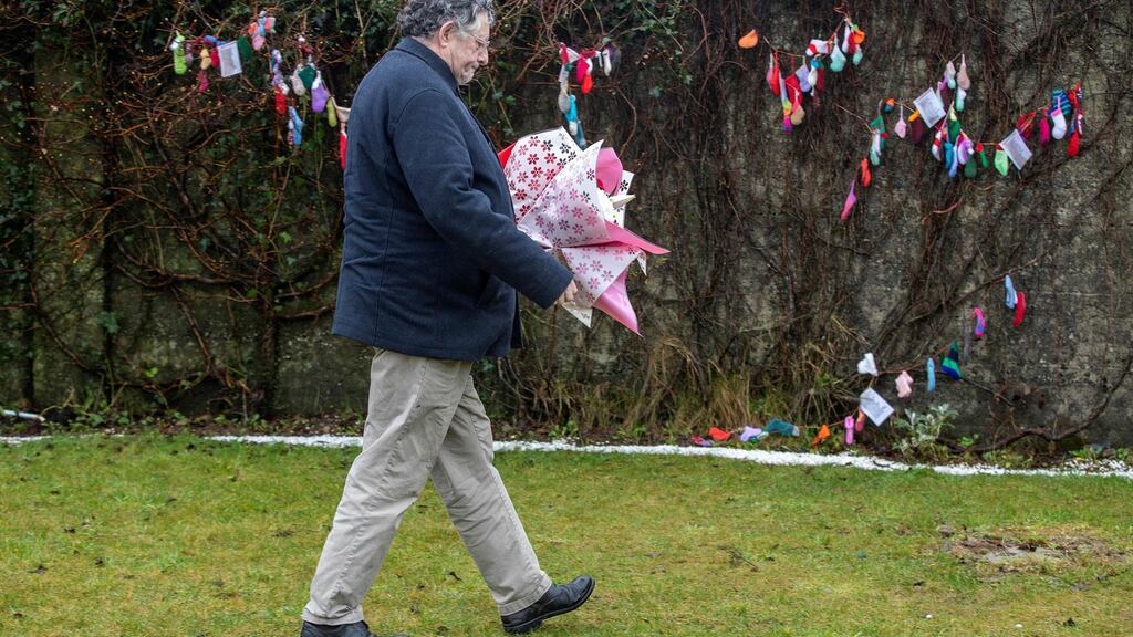 A man lays flowers this week at a shrine in Tuam, Co Galway, erected in memory of up to 800 children buried at the site of the mother and baby home there. Photograph: Paul Faith/AFP/Getty