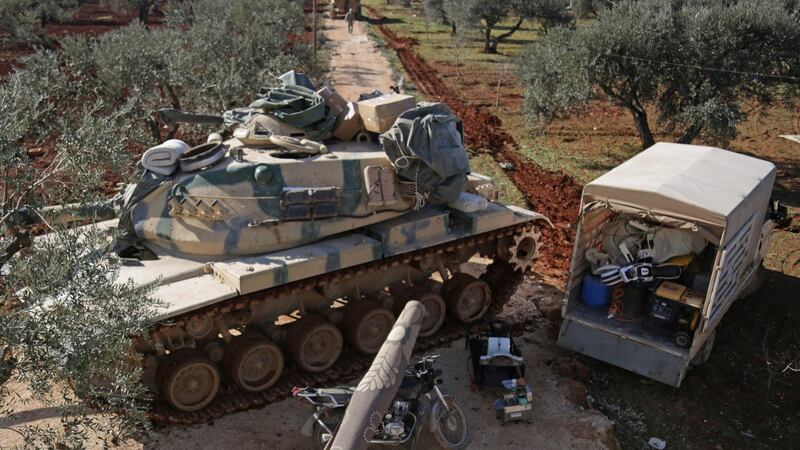 Syrians load their belongings onto a truck parked next to a Turkish military vehicle in the village of Qaminas, about 6km southeast of Idlib city in northwestern Syria   following weeks of battles in the rebel-held Idlib region. Photograph: Aref Tammawi/AFP