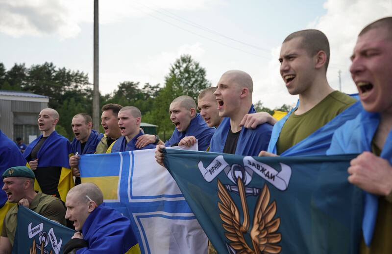 Freed Ukrainian POWs of war pose with flags following a prisoner swap with Russia. Photograph: EPA