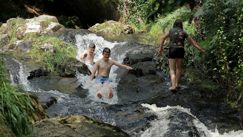 Daithi Dignam, Ben Noone (centre) and Kara Dignam taking a cooling plunge in the Shankill River, Manor Kilbride, Dublin. Photograph: Nick Bradshaw/The Irish Times