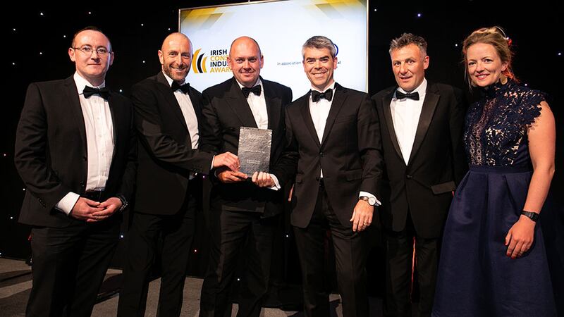 Kieran Cusack, Managing Director, Conack Construction presents the Retail Project of the Year award to De Siún architects & Project tiles team.