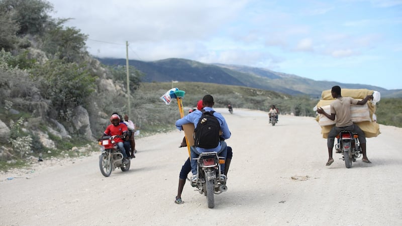 People carrying goods ride motorbikes on the road from the border with the Dominican Republic in Malpasse, Haiti. Photograph: REUTERS/Andres Martinez Casares