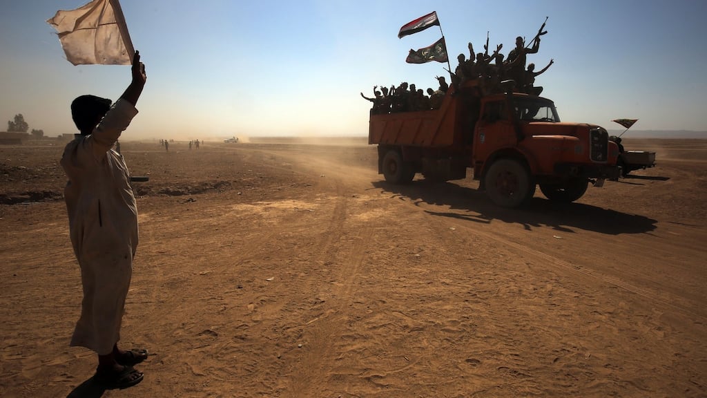 An Iraqi man waves a white flag as Iraqi forces and fighters from the Hashed al-Shaabi advance towards the Islamic State stronghold of Hawija. Photograph: Ahmad al-Rubaye/AFP/Getty Images