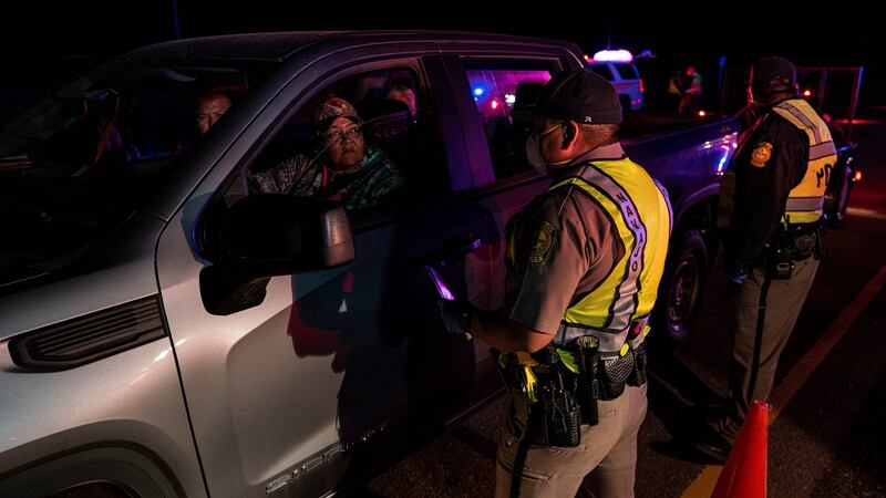 Navajo police officers inform drivers near about the nightly curfew caused by coronavirus. The 200-strong force is charged with enforcing the 8pm curfew every night. Photograph: Adriana Zehbrauskas/New York Times