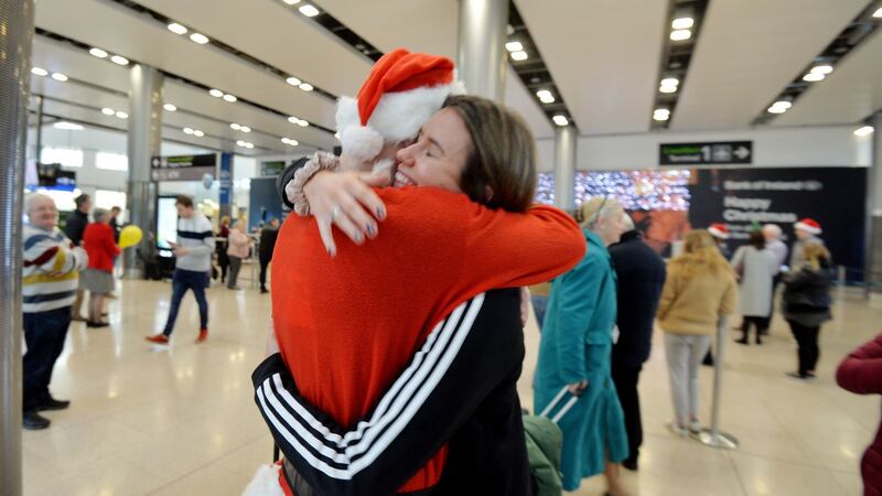 Briain McGeary dressed as Santa embraces his sister Brónagh on her arrival back from Vancouver after one year. Photograph: Alan Betson / The Irish Times