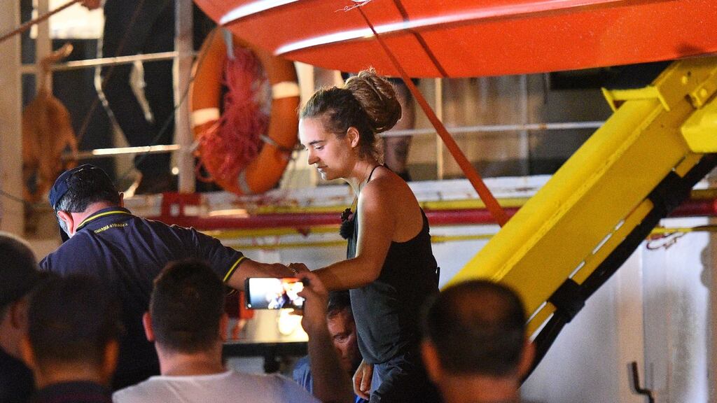 Carola Rackete, the 31-year-old Sea-Watch 3 captain, is escorted off the ship by police and taken away for questioning, in Lampedusa, Italy. Photograph: Reuters/ Guglielmo Mangiapane