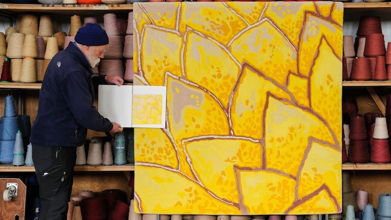British artist Derrick Greaves with a hand-tufted carpet of one of his artworks
