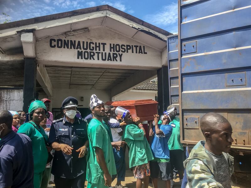 Mortuary workers place the coffins of the people killed in the August protests on trucks. Photograph: Sally Hayden