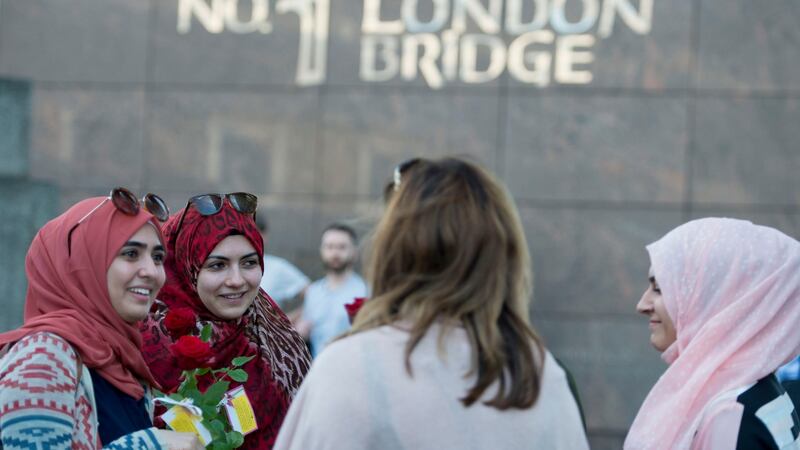 Roses with messages are given out to passers-by on London Bridge.