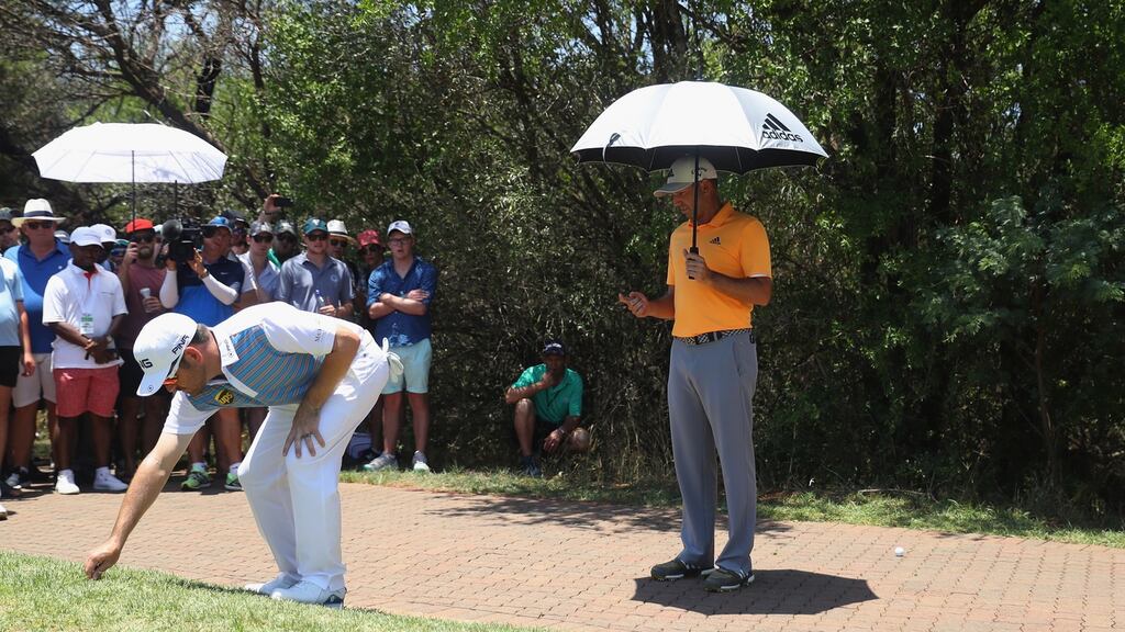 Sergio Garcia assists Louis Oosthuizen with taking a drop on the eighth hole during the third round of the Nedbank Golf Challenge in Sun City, South Africa. Photograph: Warren Little/Getty Images