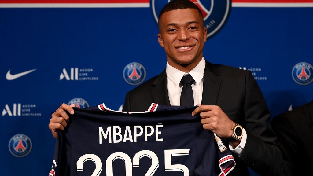 Paris Saint-Germain’s French forward Kylian Mbappe poses with a jersey at the end of a press conference at the Parc des Princes. Photograph: Franck Fife/AFP via Getty