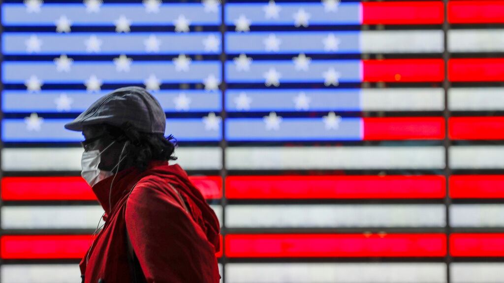 Pedestrians wearing a protective mask during the coronavirus pandemic walks along Seventh Avenue in Times Square, New York. Photograph: Frank Franklin II/AP Photo