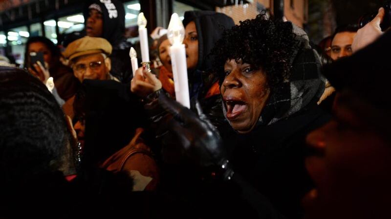 People sing during a candlelight vigil for two police officers who were killed in Brooklyn, New York. The two officers, Wenjian Liu and Rafael Ramos, were gunned down while sitting in their car by Ismaaiyl Brinsley, who later took his own life when confronted by police. Photograph: Justlin Lane/EPA