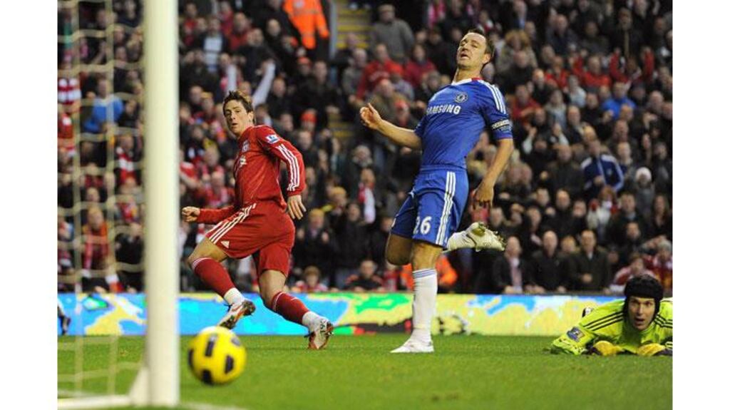 Liverpool's Fernando Torres scores the opening goal of the game as Chelsea goalkeeper Petr Cech (floor) and John Terry (centre) look on, during the Premier League match at Anfield. (Photograph: Martin Rickett/PA Wire)
