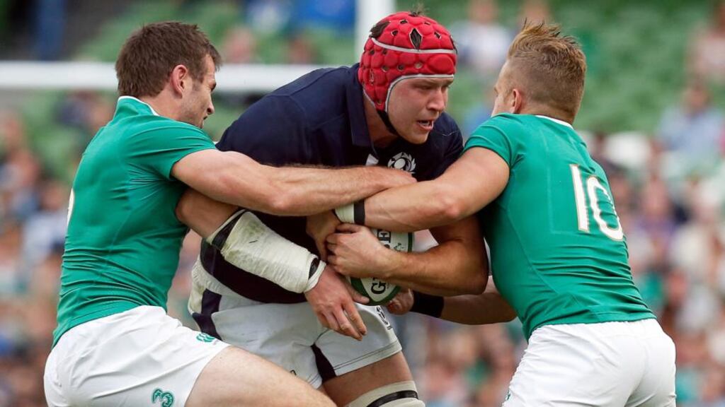 Scotland’s Grant Gilchrist is tackled by Ireland’s Mike Ross and Ian Madigan. Photograph: Cathal McNaughton/Reuters