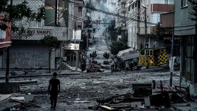 A protester walks by the Cemevi square during clashes with Turkish riot police in Istanbul’s Gazi district. Photograph: Ozan Koseozan Kose/AFP/Getty Images