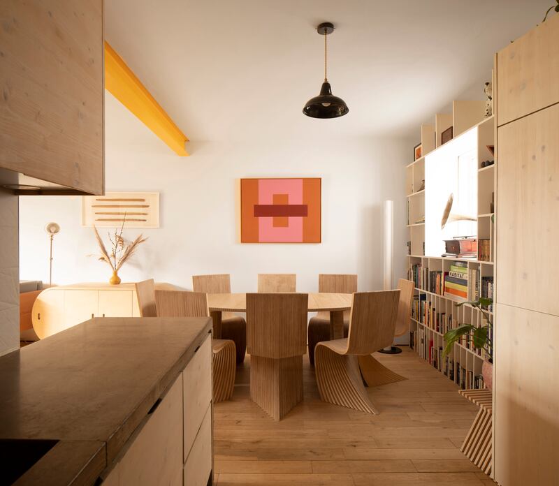 Living room and dining area featuring the curved birch plywood table, with a recessed fruit bowl, inspired by a currach, and the striking Unfurl chair.
