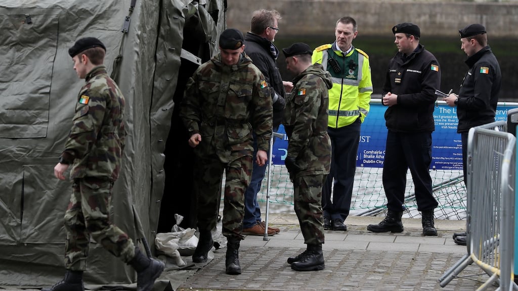 A member of the National Ambulance Service with members of the defence forces on Sir John Rogerson’s Quay in Dublin. Defence forces tents have been set up as a testing centre for Covid-19. Photograph: Brian Lawless/PA Wire