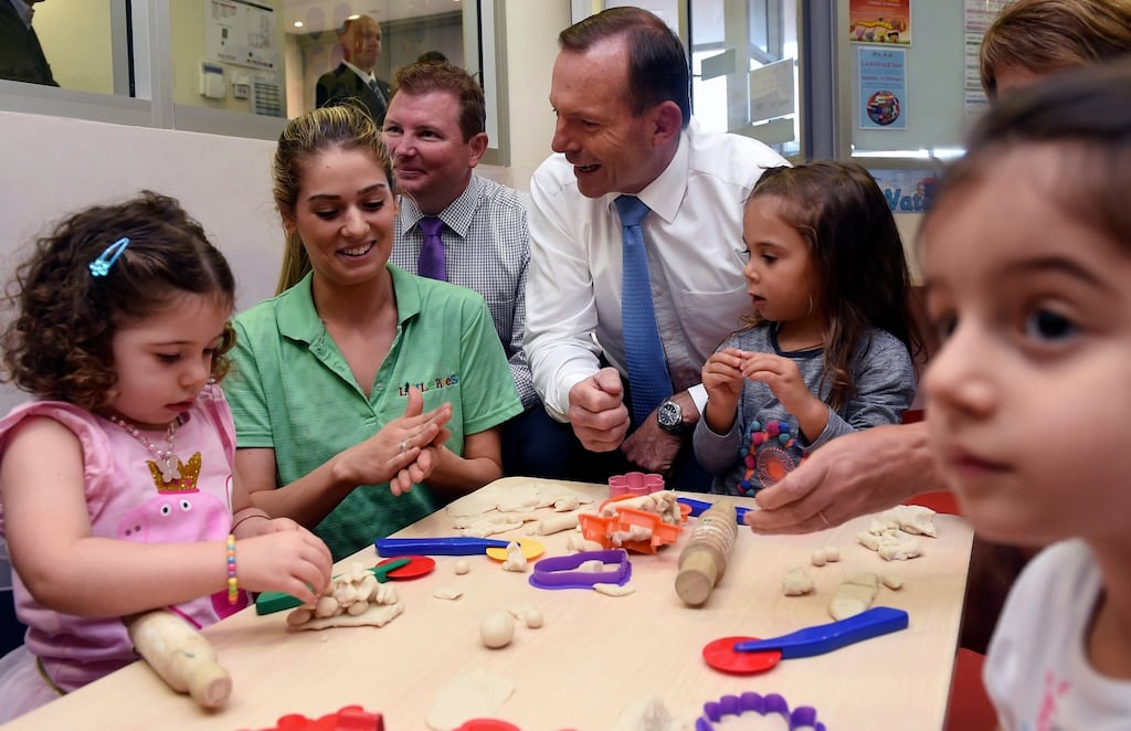 Australian Prime Minister Tony Abbott reacts as he watches children playing during his visit to the Little Pines Childcare Centre in Sydney, Australia. Abbott announced that the 1.5 per cent levy on the nation’s 34-hundred biggest companies will be invested in child care instead of the dropped parental leave scheme. (Photograph: Paul Miller/EPA)