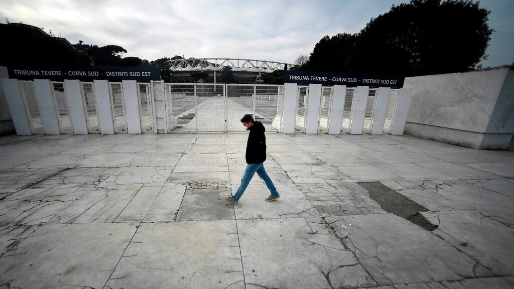 A man walks past the closed gates of the Stadio Olimpico in Rome - one of the host grounds for the postponed Euro 2020. Photograph: Filippo Monteforte/Getty/AFP