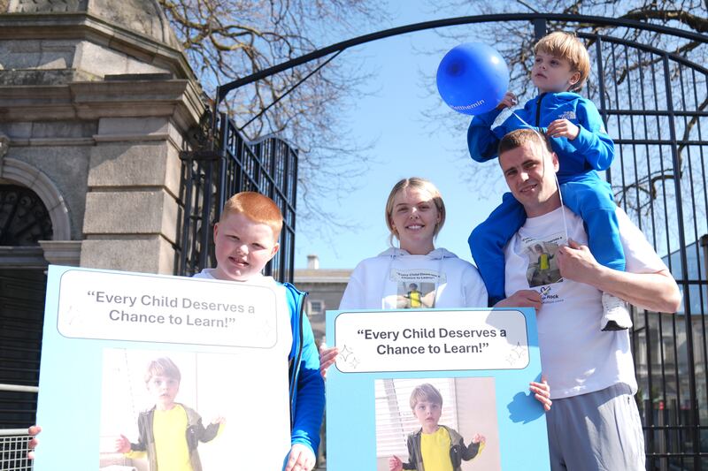 Jasmine Graham and Adam Rock with their son Lewis (6), who were among dozens of parents protesting outside Leinster House. Photograph: Brian Lawless/PA Wire