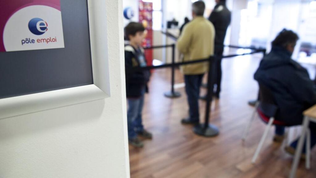The Pole Emploi logo sits on display as jobseekers queue inside a branch of the French national employment agency. Photograph: Balint Porneczi/Bloomberg