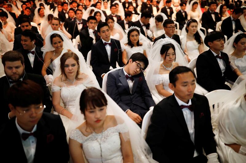 A groom naps as couples attend a mass wedding ceremony of the Unification Church, at CheongShim Peace World Centre in South Korea. Photograph: Kim Hong-ji/Reuters