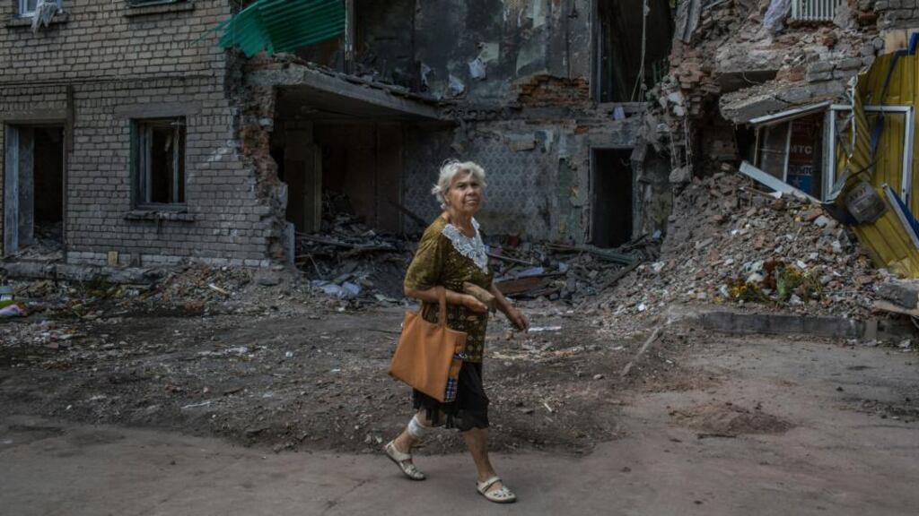A woman walks by a damaged apartment building reportedly struck by a rocket, in Snizhne, about 50km east of Donetsk, in eastern Ukraine. Photograph: Mauricio Lima/The New York Times
