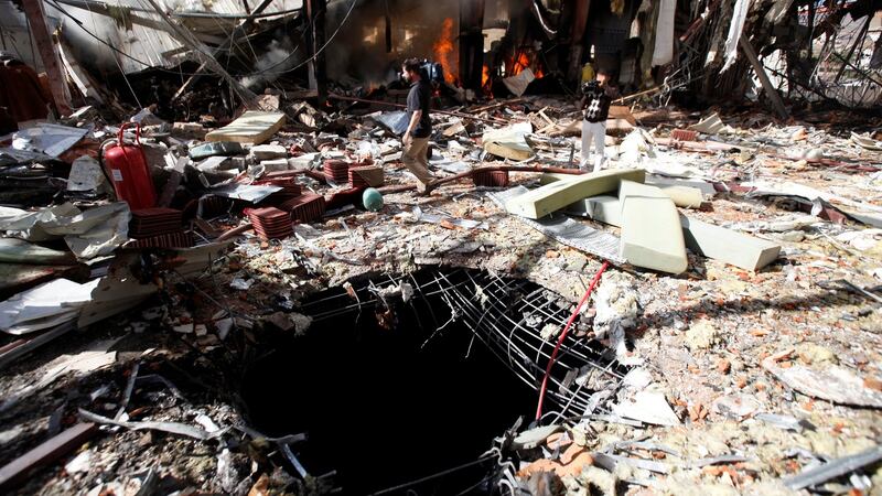 A cameraman walks by a hole on the floor of the community hall where Saudi-led warplanes struck a funeral in Sanaa, the capital of Yemen. Photograph: Reuters