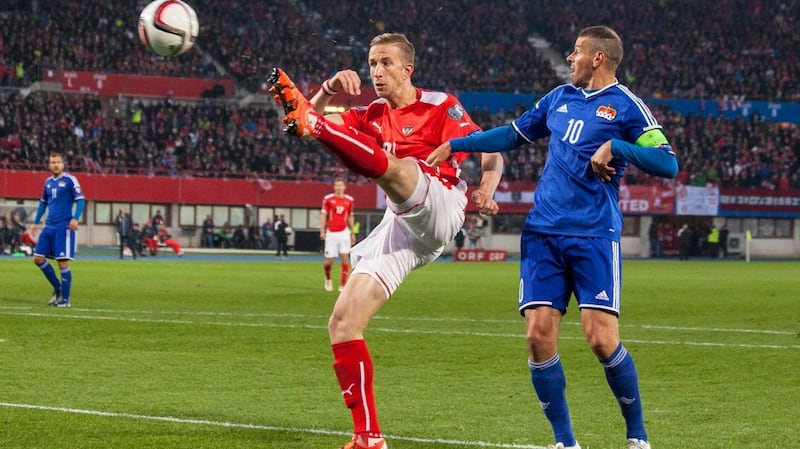 Marc Janko of Austria (left) competes for the ball with Mario Frick of Liechtenstein. Photograph: Getty