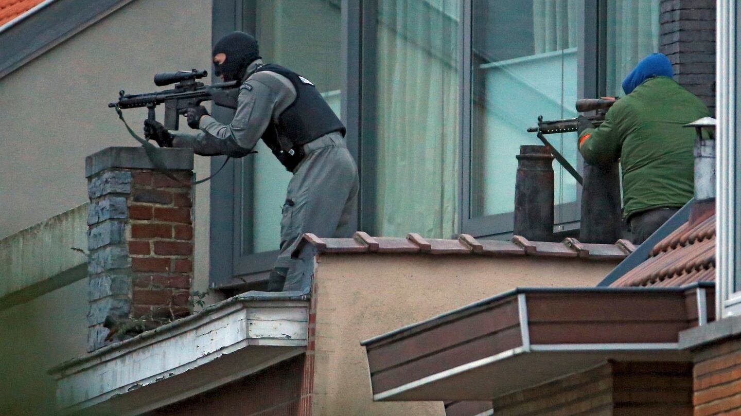 Masked Belgian police secure the area from a rooftop near the scene where shots were fired during a police search of a house in the suburb of Forest near Brussels, Belgium. Photograph: Yves Herman /Reuters