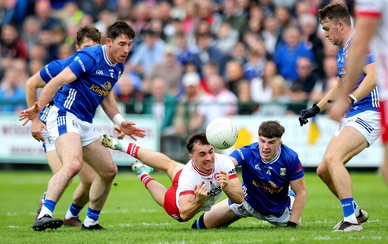 Tyrone’s Darragh Canavan makes a pass under pressure from Cian Reilly of Cavan. Photograph: Ryan Byrne/Inpho