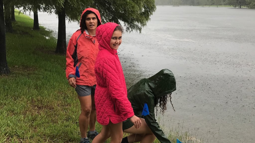 Sarah McKevitt with her daughters Alannah and Izzie marking the level at the lake at the back of their house, which leads to the Addick’s reservoir.